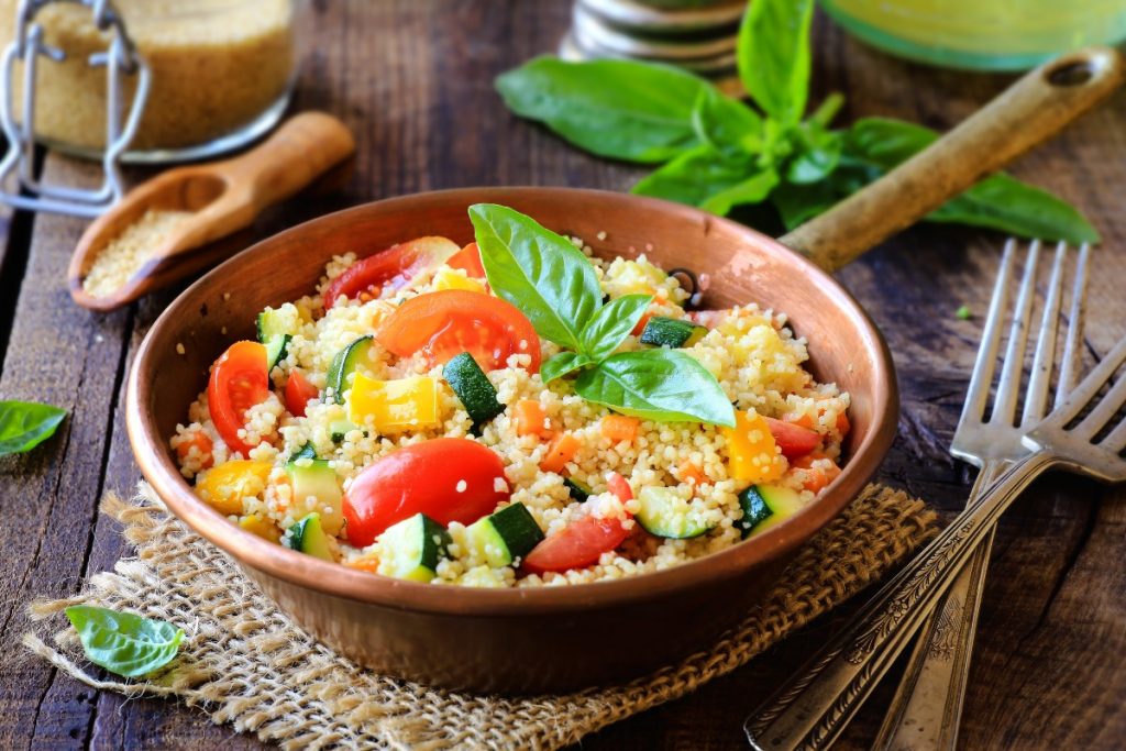 padella con manico piena di cous cous di verdure e foglie di menta