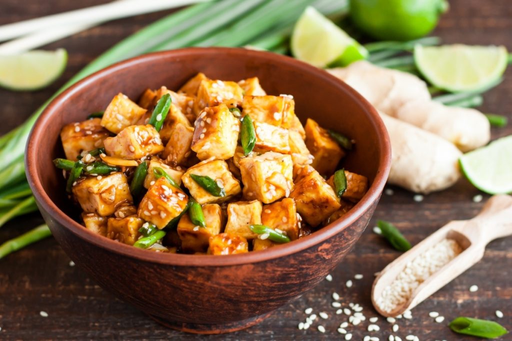 scodella con pezzetti di tofu e verdure su base di legno