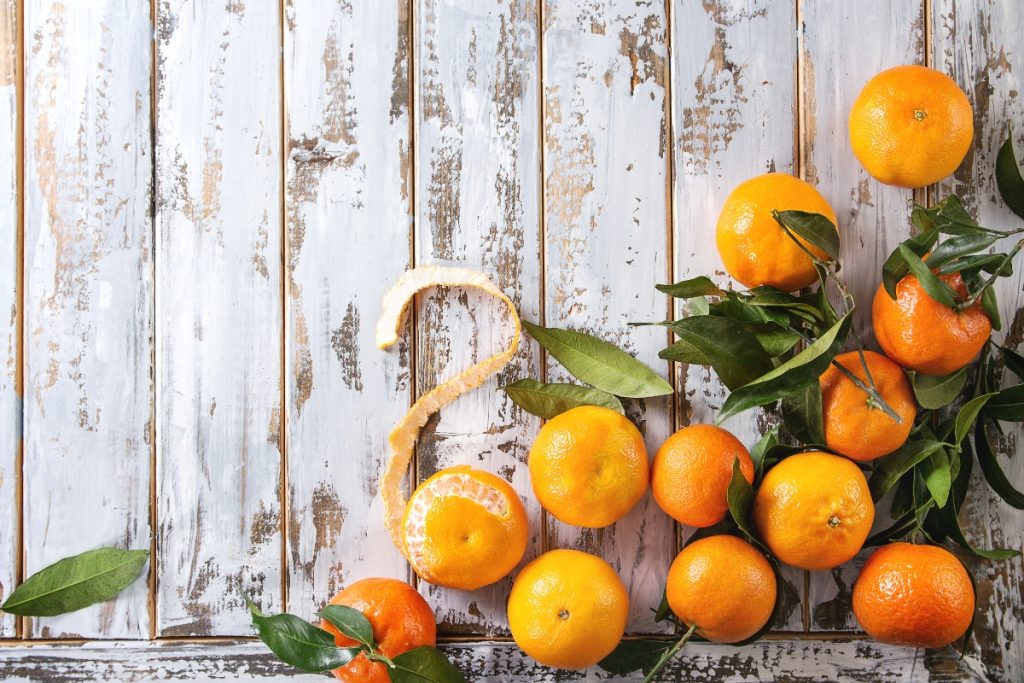 alcune clementine sparse su un tavolo di legno bianco