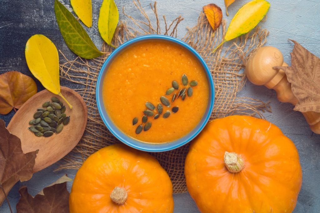 due zucche e una ciotola con passata di zucca