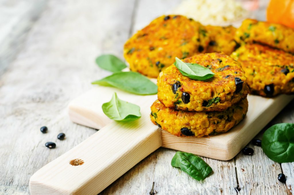 ricette con miglio: primo piano di un tagliere con polpette di miglio e salvia