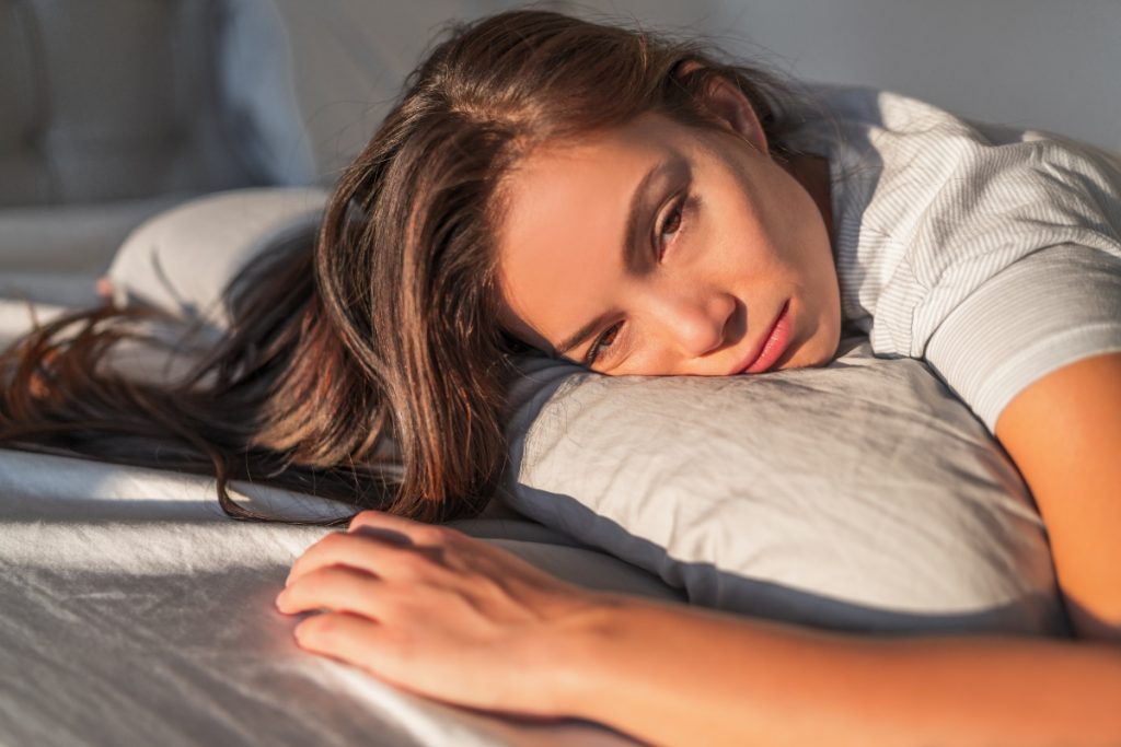 una donna molto stanca sdraiata sul letto