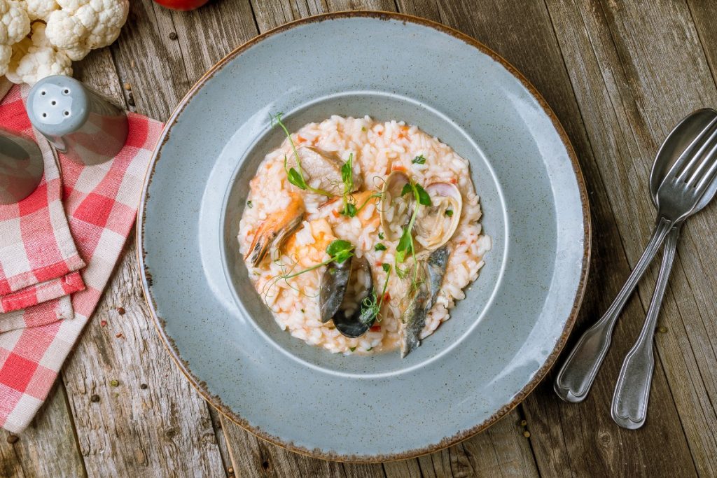 un piatto con risotto ai frutti di mare, forchetta e cucchiaio