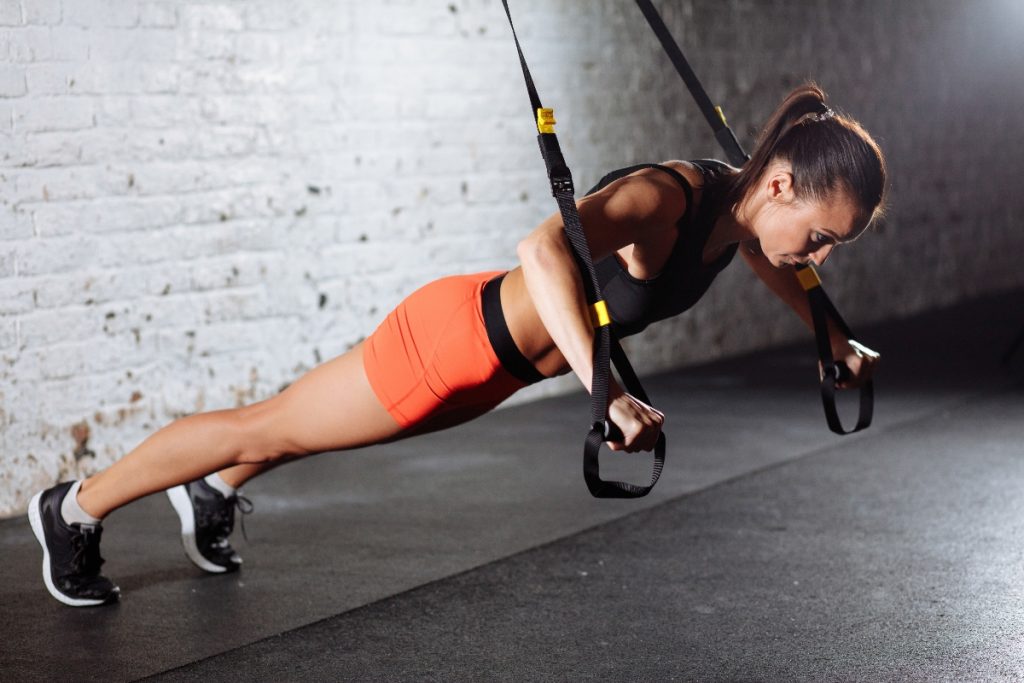 donna in palestra si allena con il TRX