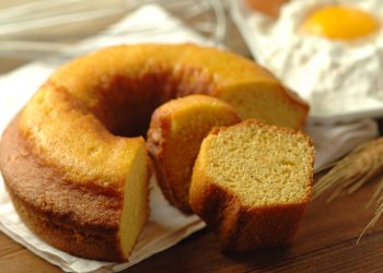 un ciambellone tagliato su un tavolo accanto a dei rossi di uovo