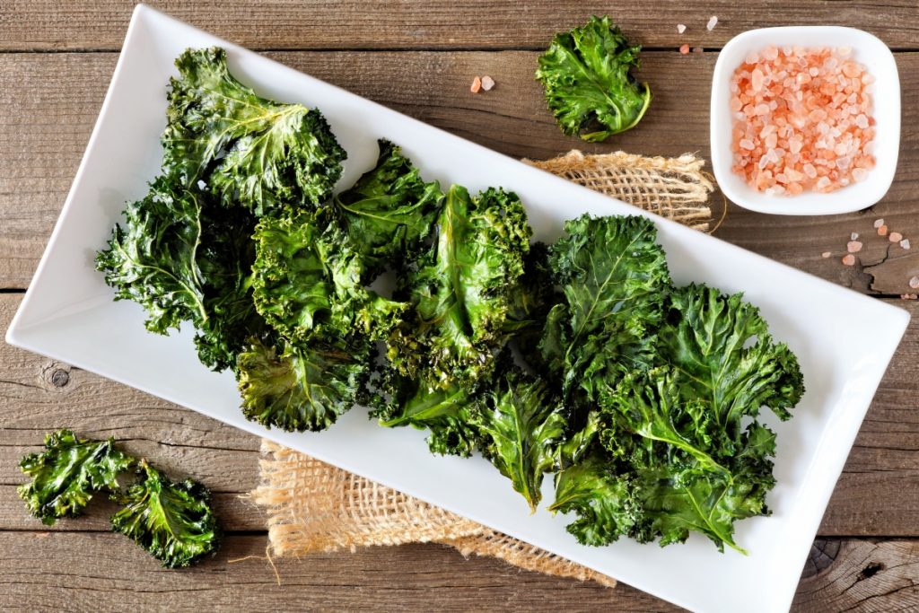 su base di legno piatto bianco rettangolare con foglie di cavolo nero