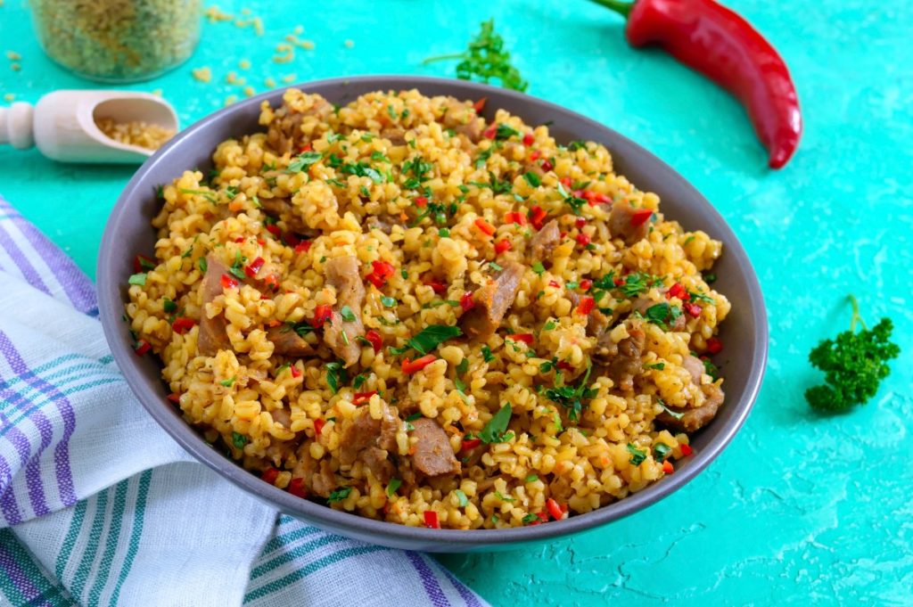 scodella piena di cous cous su piano turchese