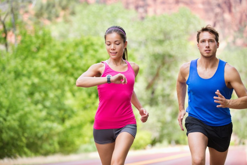 coppia che corre mentre la donna guarda il cardiofrequenzimetro