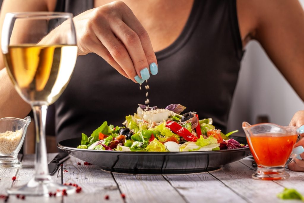 una donna che mangia un'insalata con lo sgombro