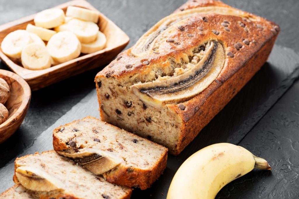 un vassoio con banana bread affettato, rondelle di banane e banana intera