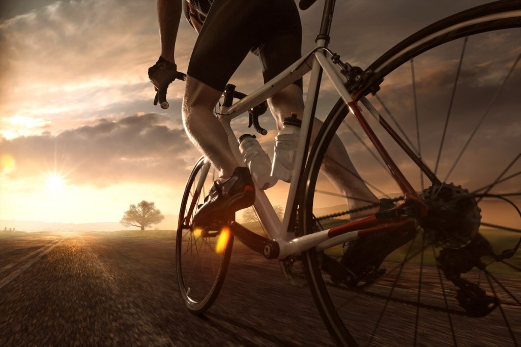 Un uomo che pedala al tramonto