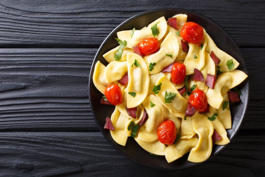 su fondo scuro una scodella nera piena di casoncelli, i ravioli di Bergamo