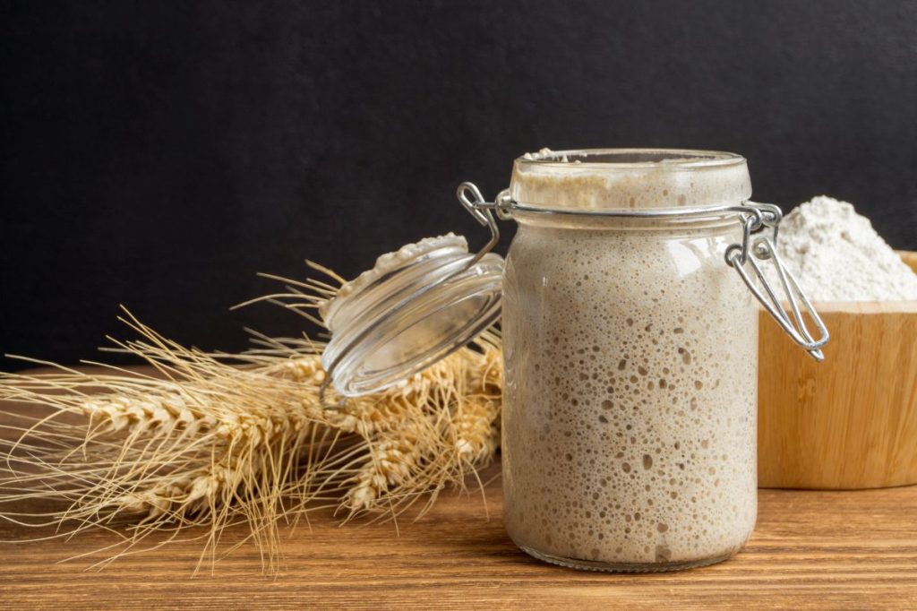 Un barattolo con lievito madre, spiga di grano