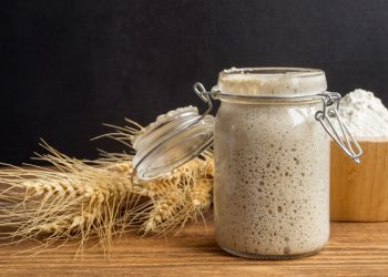 Un barattolo con lievito madre, spiga di grano