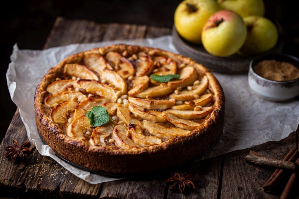 una torta di mela e ricotta, soffice su base di legno