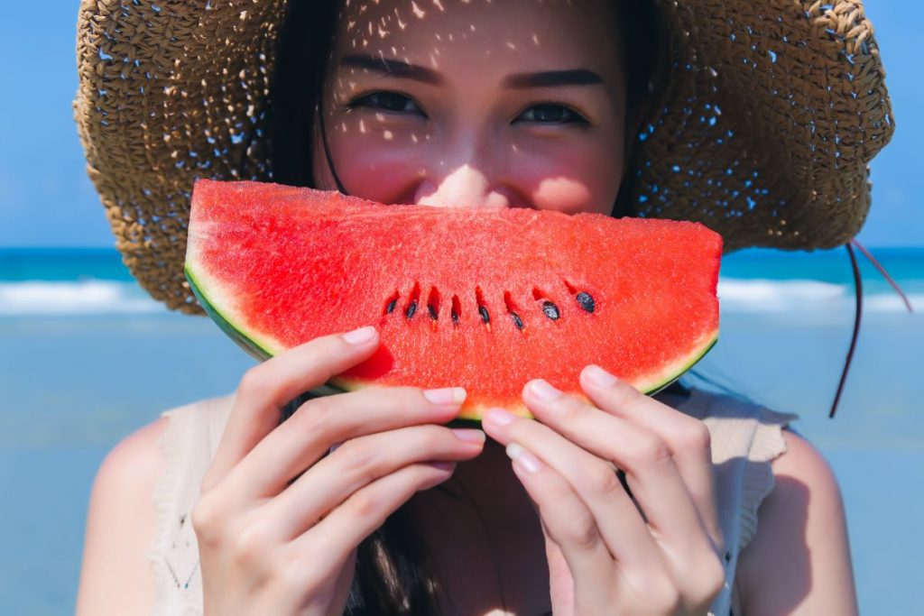 Una giovane donna che tiene in mano una fetta di cocomero