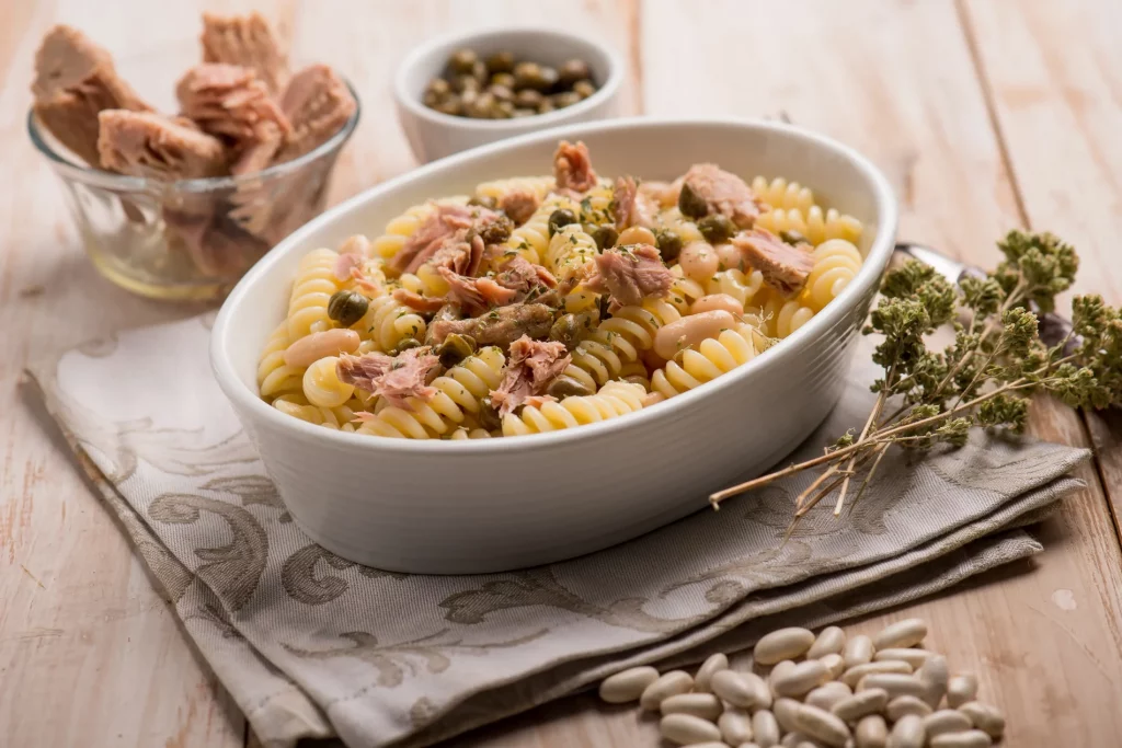 una zuppiera ovale piena di fusilli al tonno in bianco