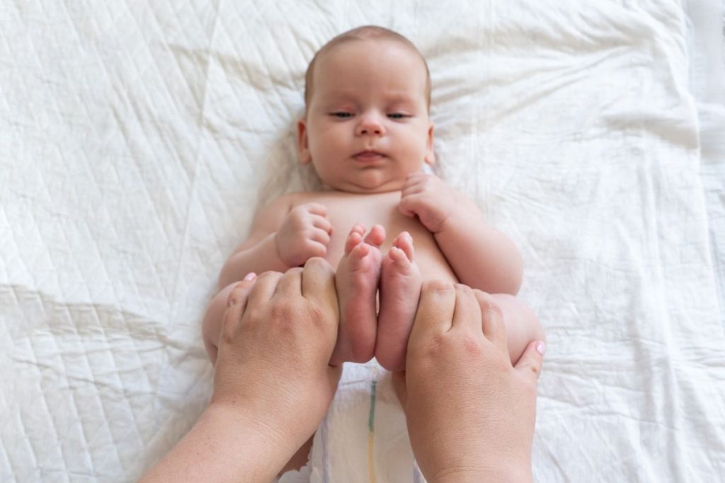 Una mamma che cambia il pannolino al neonato