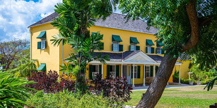 villa gialla immersa nel verde tropicale dell'isola Barbados