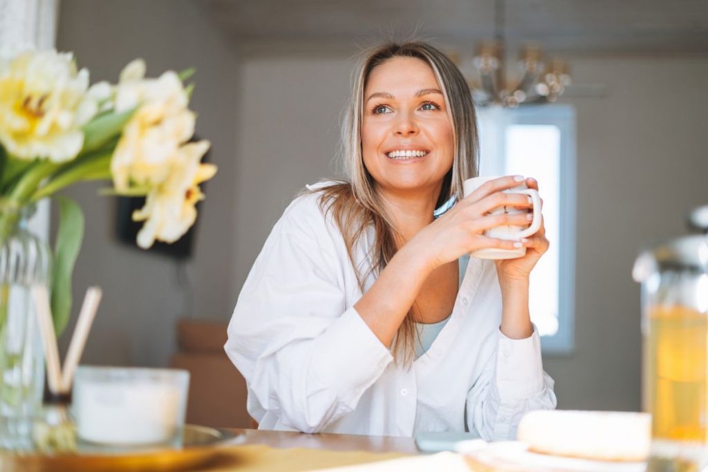 Una donna che beve una tisana come rimedio naturale per la ritenzione idrica