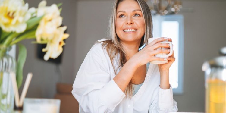 Una donna che beve una tisana come rimedio naturale per la ritenzione idrica