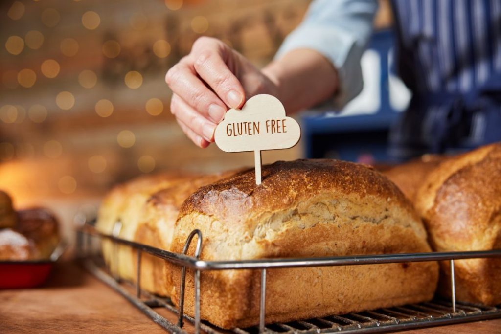 una forma di pane in cassetta con sopra un piccolo cartello con scritto gluten free (cibi senza glutine)