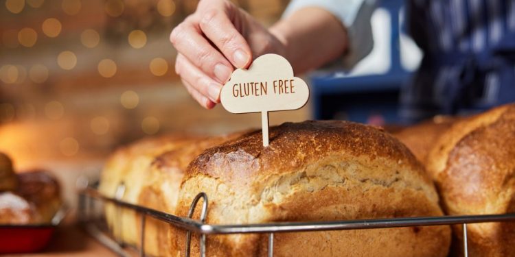 una forma di pane in cassetta con sopra un piccolo cartello con scritto gluten free (cibi senza glutine)