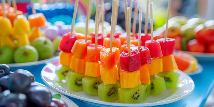 tavola con buffet piena di frutta e colorati spiedini di frutta estiva con kiwi, melone e anguria