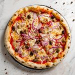 su piano di cucina di marmo una pizza con tonno e cipolle di Tropea