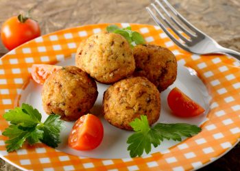 piatto colorato con polpette di pesce spada, pomodorini e prezzemolo