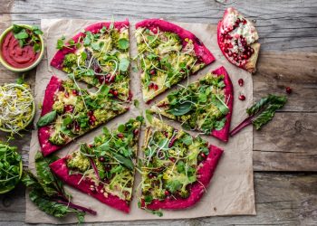 su tavolo di legno pietra refrattaria con pizza di verdure e melagrana