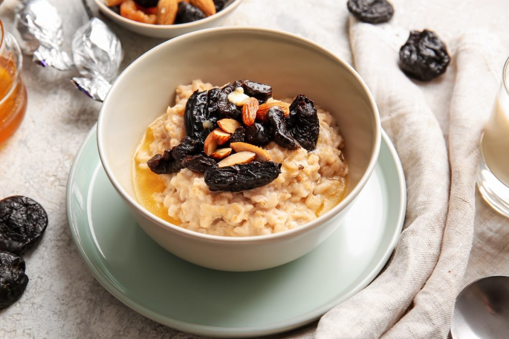 piattino e ciotola con cereali e prugne secche