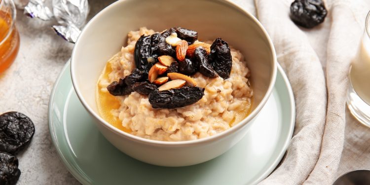 piattino e ciotola con cereali e prugne secche