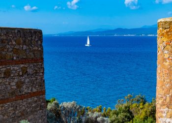 panoramica vista da una torre antica sul mare con barca a vela sullo sfondo