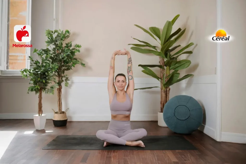 donna sul tappetino mentre esegue una posizione yoga, un pallone e tre piante