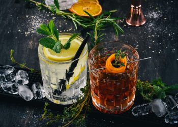 su tavolo di marmo 2 cocktail alcolici: gin tonic e negroni