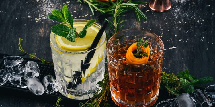 su tavolo di marmo 2 cocktail alcolici: gin tonic e negroni