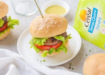 piatto tondo bianco con un hamburger infilzato da uno stecchino, scatola prodotti Cereal accanto